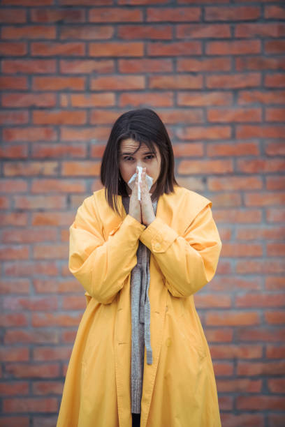 istock Sick young woman blowing her nose 1207856779