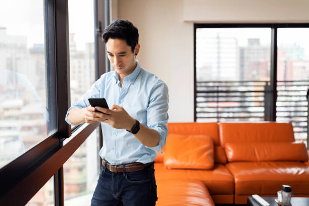istock Cute guy uses his phone 1207857819
