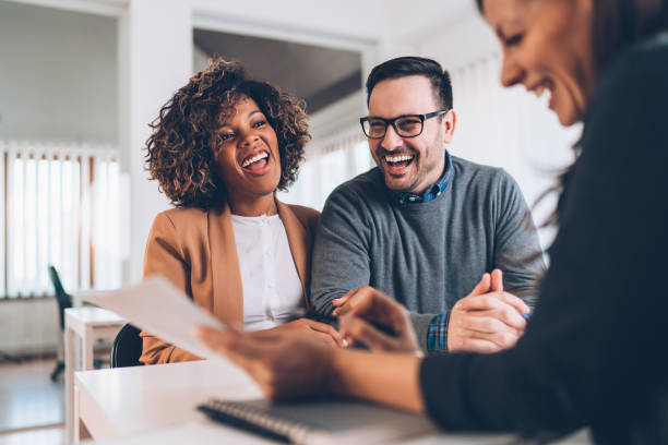 Happy couple talking with sales manager Happy couple talking with sales manager at the store travel agency stock pictures, royalty-free photos & images