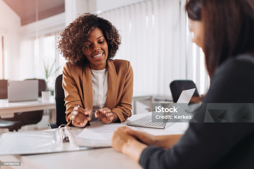 Client consulting with a agent Female client consulting with a agent in the office Advice Stock Photo