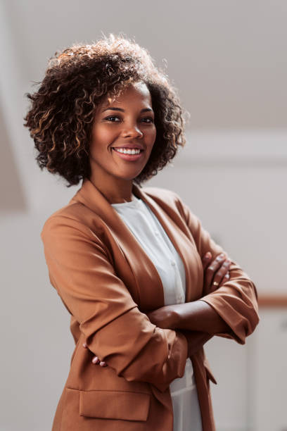 Portrait of young cheerful african american businesswoman Portrait of young cheerful african american businesswoman wearing brown suit smiling and looking at camera black business woman stock pictures, royalty-free photos & images