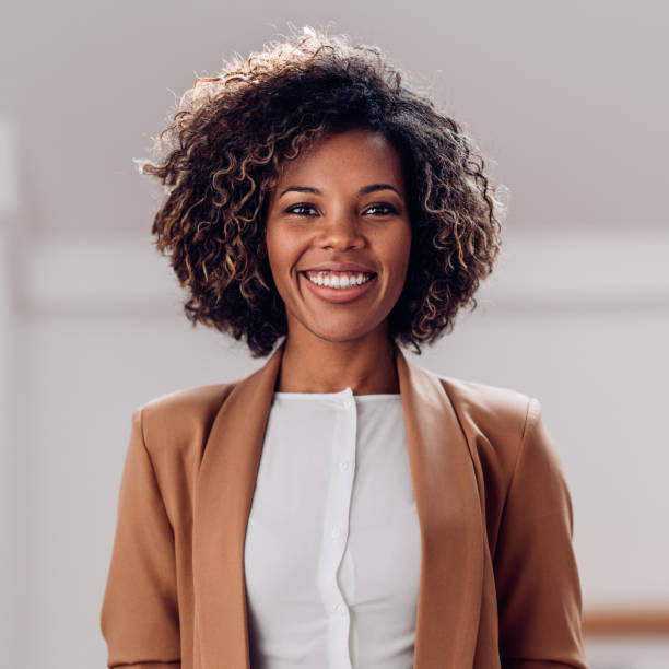Portrait of young cheerful african american woman Portrait of young cheerful african american woman wearing brown suit smiling and looking at camera natural beauty people photos stock pictures, royalty-free photos & images