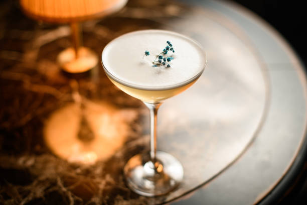 cremoso cocktail alcolico nel bicchiere decorato con un fiore secco sul tavolo - glass bar relaxation red foto e immagini stock