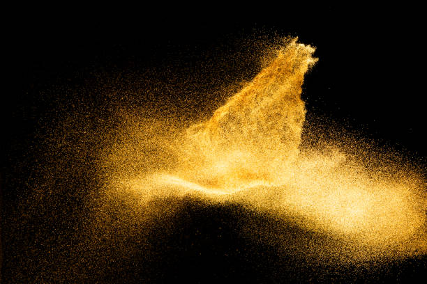 istock Golden sand explosion isolated on black background. Abstract sand cloud.Sandy fly wave in the air. 1207872171