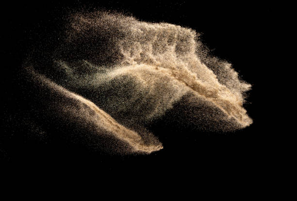 Brown colored sand splash.Dry river sand explosion isolated on black background. Abstract sand cloud.