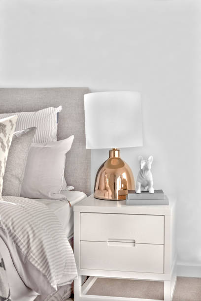 istock Bedroom with pillows and small cupboard with a gold  lamp 1207877968