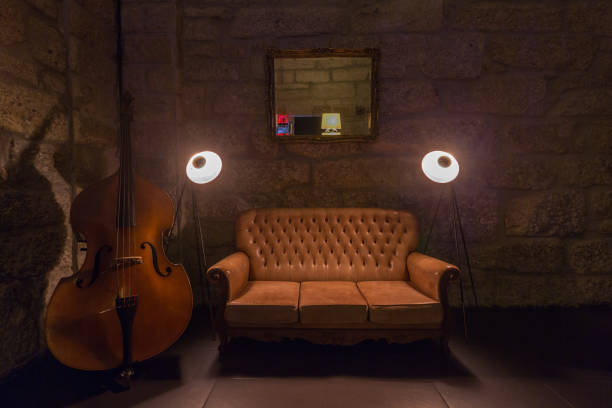 istock leather sofa, lamps and table in dark interior. Stone wall on background, brutal atmosphere 1207880633
