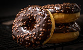 Chocolate-coated doughnuts, close-up, blurred, macro, sprinkle, delicious, assorted doughnuts, on a cooling rack, dark
