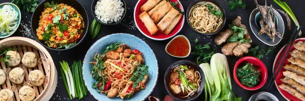 Assorted Chinese food on dark background. Asian food concept. Top view.  Panorama, banner