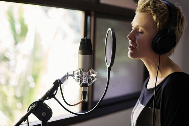 istock Singer woman sing and record with microphone at studio 1207889769