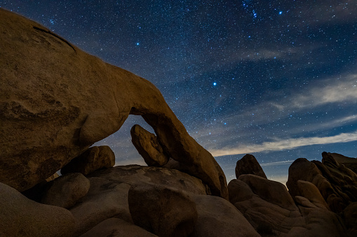 Arch Rock and starry night sky in Joshua Tree National Park.