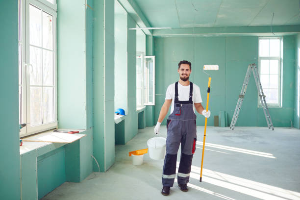 Bearded painter construction worker on a construction site. Bearded painter smiling construction worker with tools on a construction site. house painter stock pictures, royalty-free photos & images