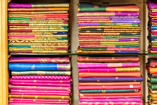 Ropa india colorida tradicional apilada en un showroom textil photo