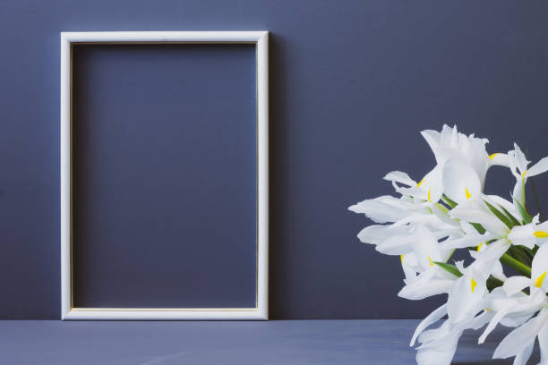 istock white flowers and white photo frame on gray background copy space 1207896276