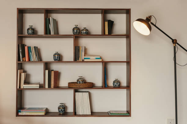 Modern interior room with a beautiful furniture. Minimalist bookshelf over dramatic concrete background, modern art. 3d render.