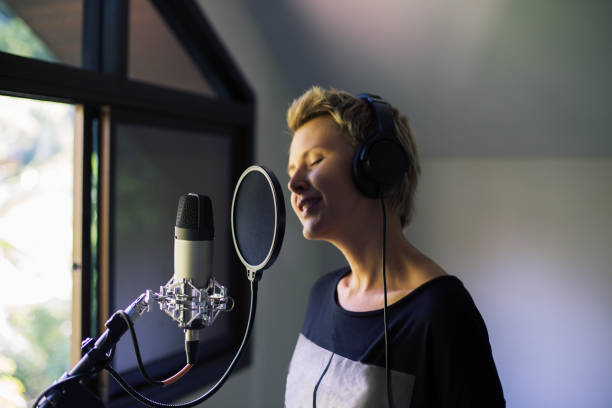istock Singer woman sing and record with microphone at studio 1207903535