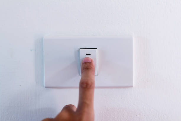 istock Close up of finger is turning on or off on light switch. 1207908463