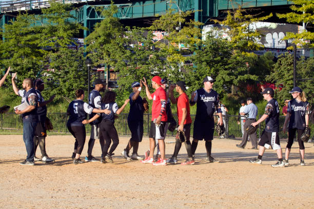 Bronx, New York/USA - August 10, 2019: Two teams share high fives after baseball game in public park.