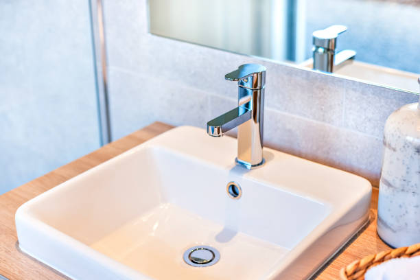 istock Closeup of a silver taps and ceramic sink 1207908884