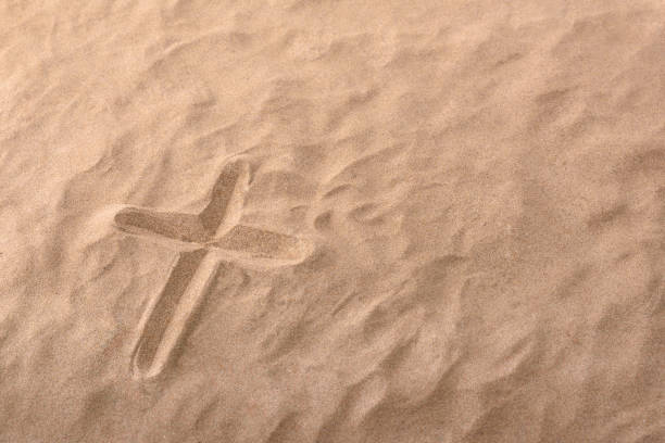 Cross as religious symbol engraved in the sand. Horizontal composition