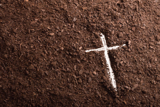 istock White cross engraved on the ground with the finger 1207912196