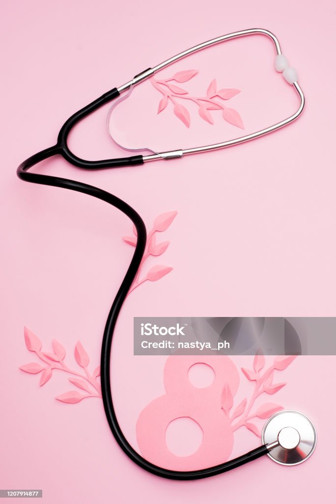 World Women's Day, March 8th, stethoscope and paper leaves on pink background with copy space Doctor Stock Photo