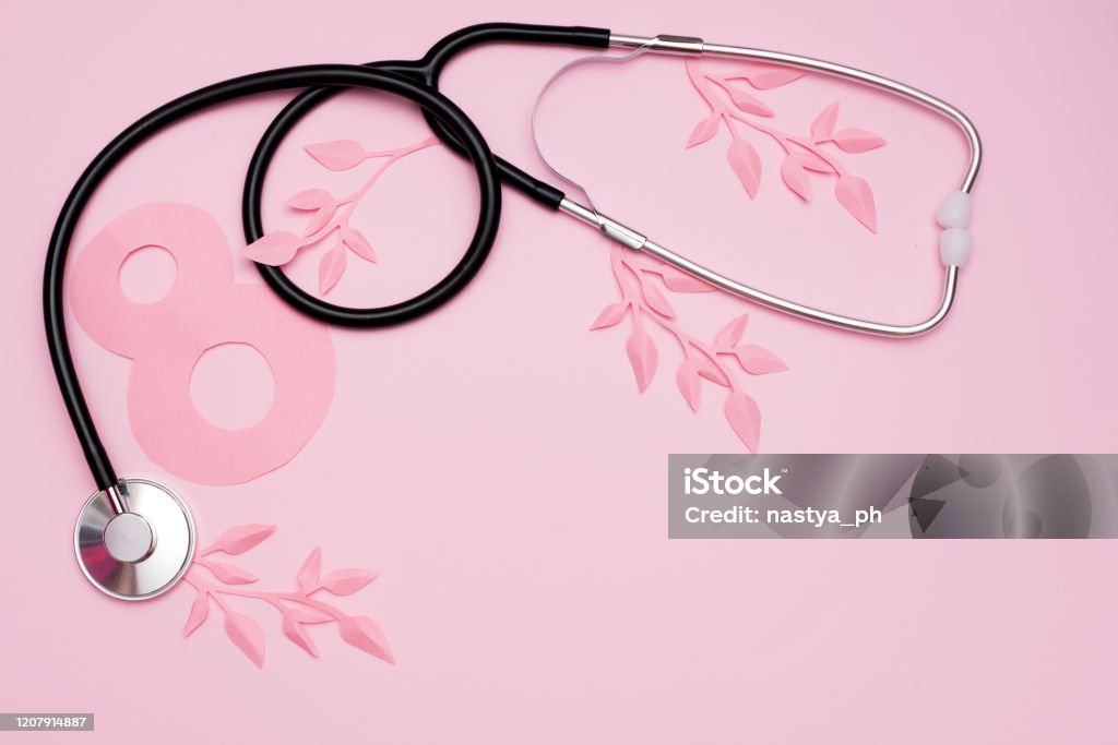 World Women's Day, March 8th , stethoscope and paper leaves on pink background with copy space, health concepts. International Womens Day Stock Photo