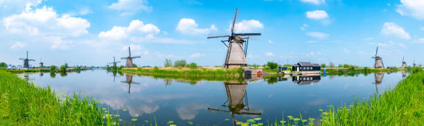 panorama de los molinos de viento y la reflexión sobre el agua en kinderdijk, patrimonio de la humanidad de la unesco en rotterdam, países bajos - windmill architecture traditional culture mill fotografías e imágenes de stock