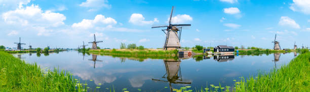 Panorama of the windmills and the reflection on water in Kinderdijk, a UNESCO World Heritage site in Rotterdam, Netherlands stock photo