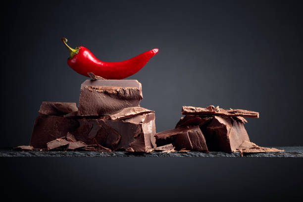istock Black chocolate with red pepper on a dark background. 1207918763