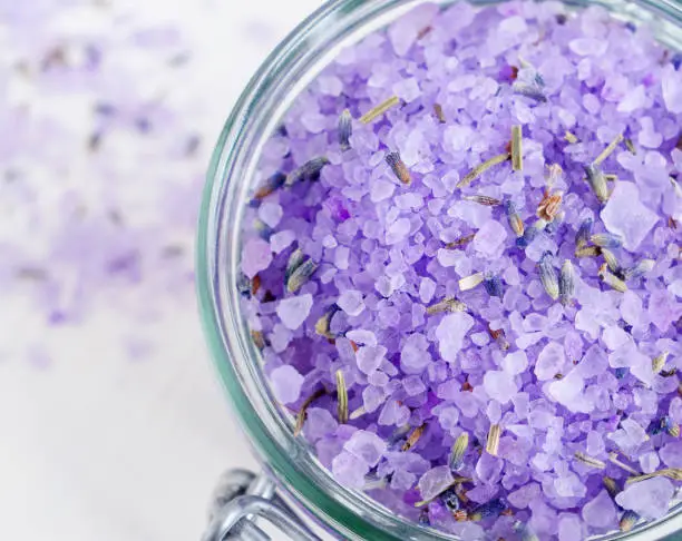 Purple bath salt (foot soak) wirh dry lavender. Top view, close up.