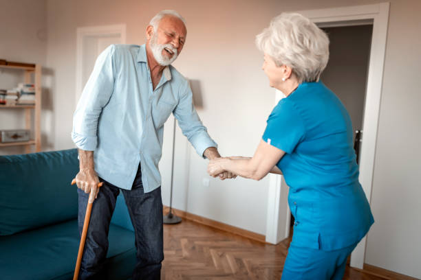 istock Female nurse supporting senior man to walk 1207922116
