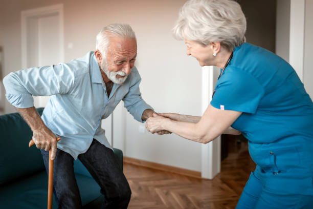 istock Female nurse supporting senior man to walk 1207922129