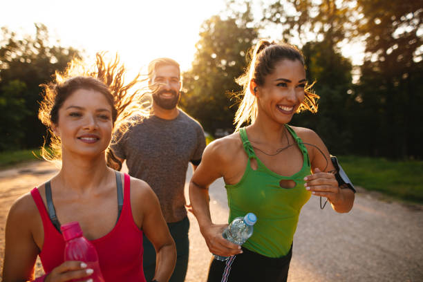 istock Three young people jogging together in nature 1207924671