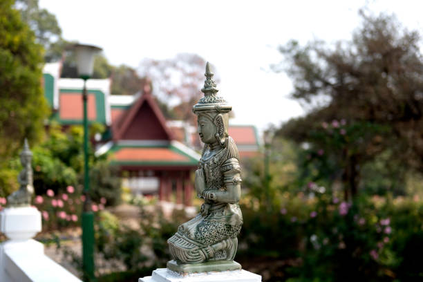 A statuette with in the background buildings of the Chang Man royal palace and a lush garden