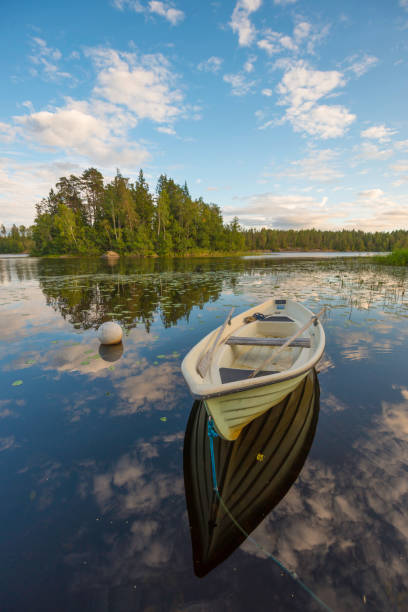 istock Reflections of boat on calm lake 1207927266