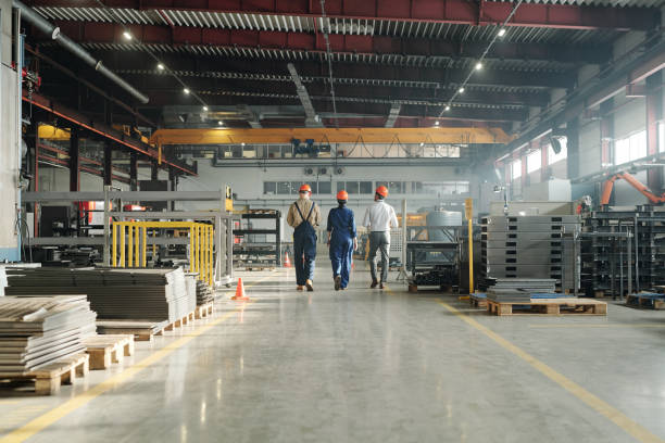 istock Rear view of three engineers leaving workshop at the end of working day 1207928554
