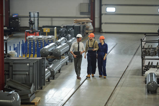 istock Group of contemporary professional technicians in workwear moving along workshop 1207928559
