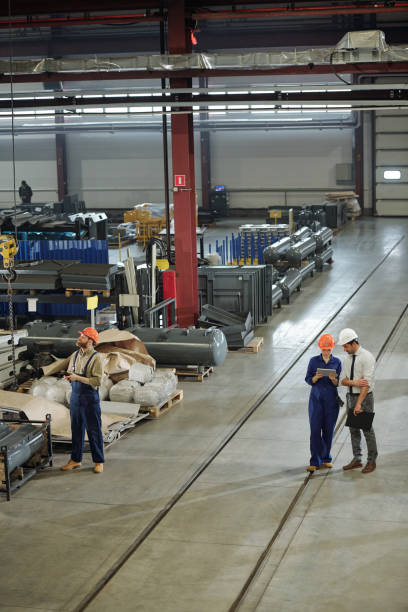 istock Two engineers networking while their colleague controling industrial machine 1207928584
