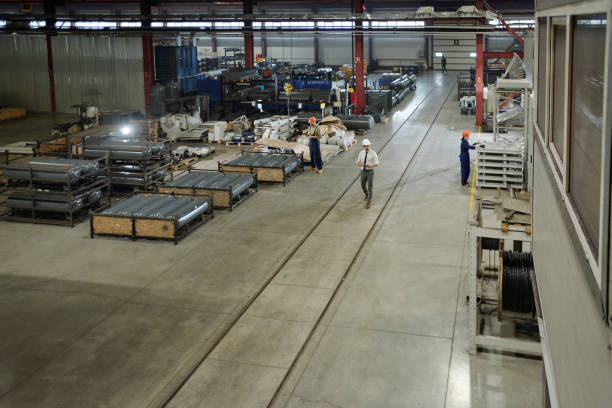 istock Large workshop of modern industrial plant with group of working engineers 1207928607