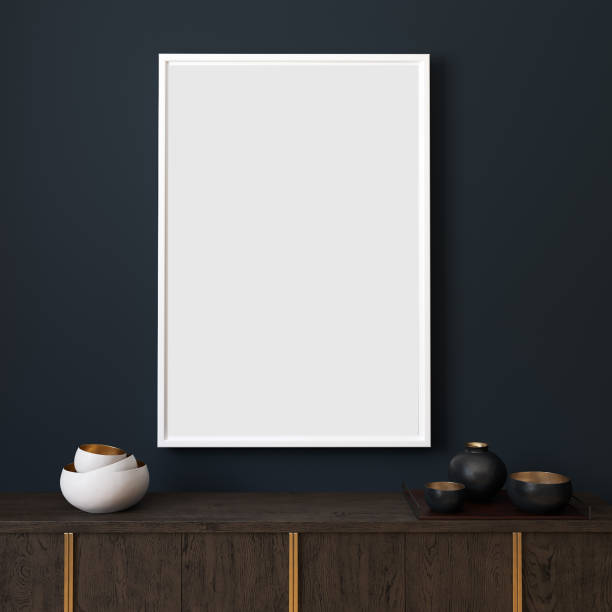 istock Picture mockup with white vertical frame on dark blue wall. Stylish dark interior with decor and wooden cupboard and blanket picture. Poster mockup. Minimalist modern interior design. 3D illustration. 1207935532