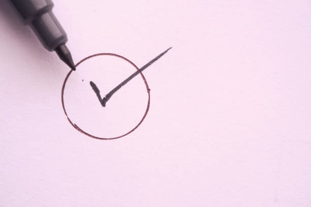 close up of check mark with pen on paper