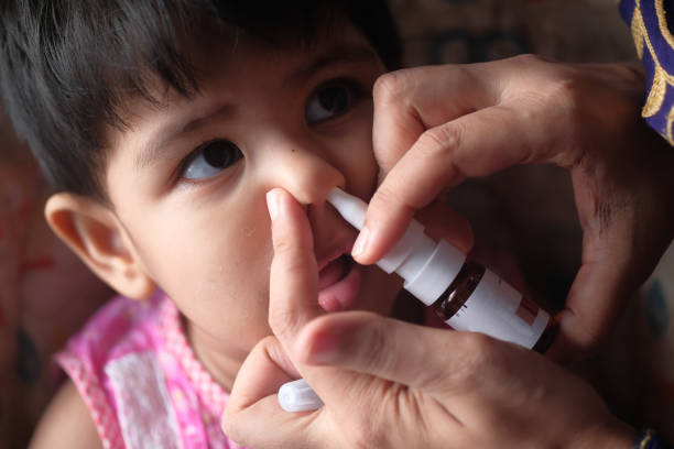 istock baby child taking medicine on nose 1207943388