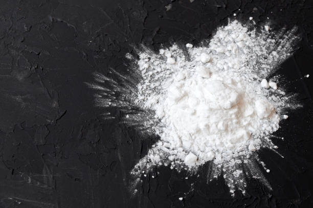 istock Corn starch on a black background, top view, copy space. Corn white starch on a black table. Potato starch on a black background. Top view, copy space. 1207944670
