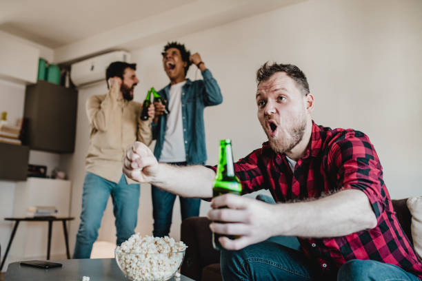 istock Friends watching sport match on tv 1207945346