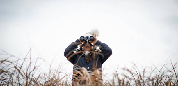 istock Girl looking far away with binoculars 1207946633