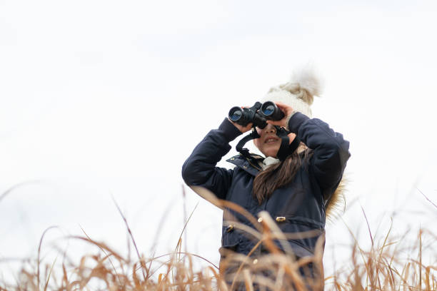 Girl looking far away with binoculars