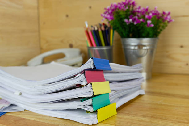 istock file folder and Stack of business report paper file on the table in a work office 1207951114