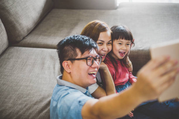 istock Happy young family taking selfies on sofa 1207952743