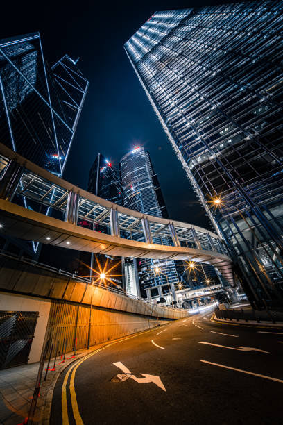 guarda il paesaggio urbano notturno del centro di hong kong dallo skywalk - hong kong night motion city foto e immagini stock